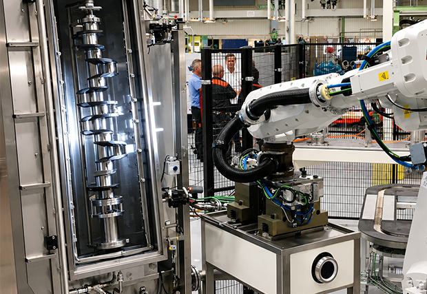 Vilebrequin chargé verticalement par un robot sur une machine de nettoyage de pièces - MecanoFAST
