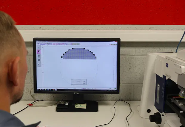 Technicien analysant des particules au microscope